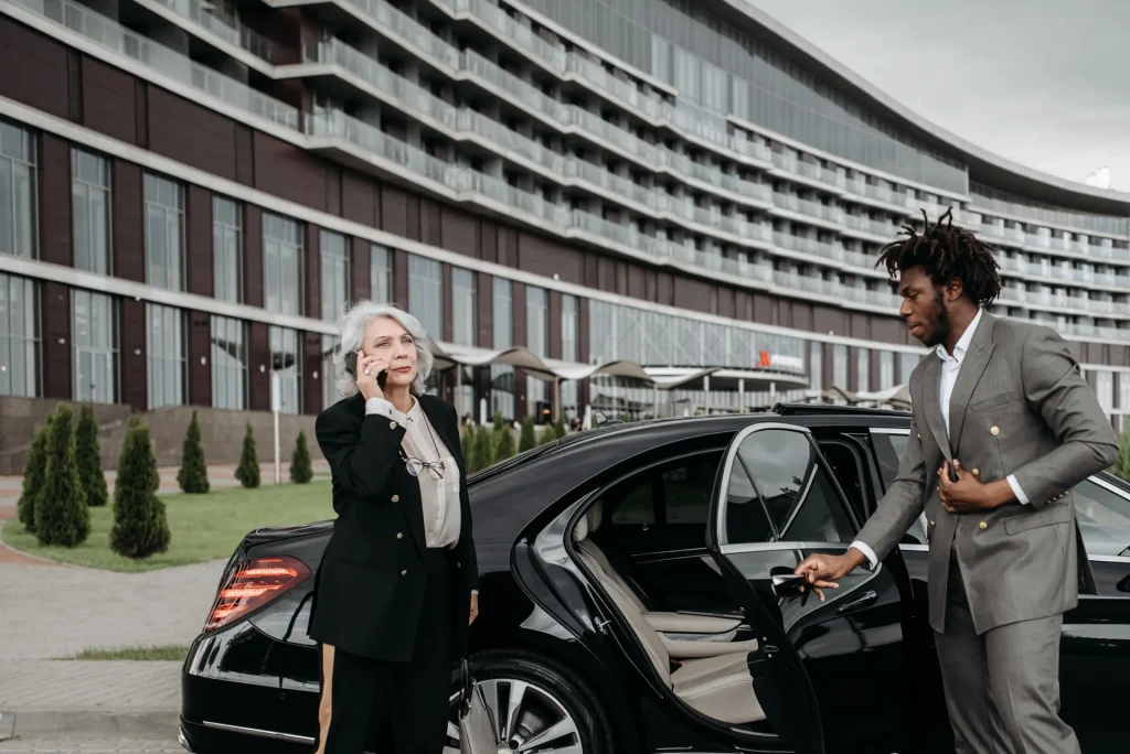 Driver opening the car door for a senior woman